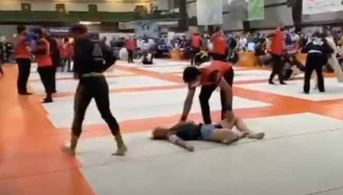 Une concurrente de BJJ sort lorsqu'elle est prise dans une guillotine serrée