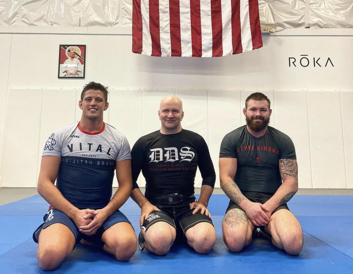 O atual mundial absoluto Nicholas Meregali, com o treinador John Danaher et Gordon Ryan. Foto: Divulgação