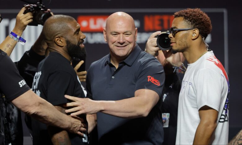 Dana White separates two fighters after a faceoff during a press conference