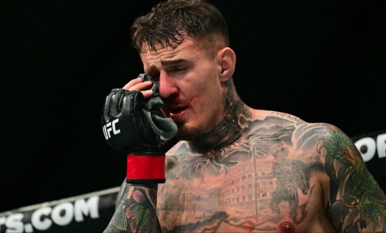 Tom Aspinall reacts after getting poked in the eyes during his fight at UFC 321