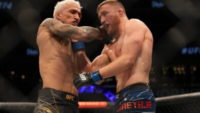 Charles Oliveira punches Justin Gaethje in their fight at UFC 274