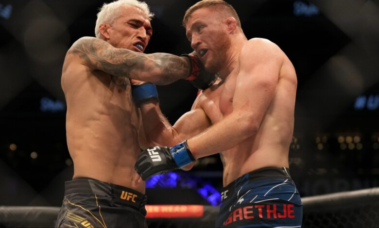 Charles Oliveira punches Justin Gaethje in their fight at UFC 274