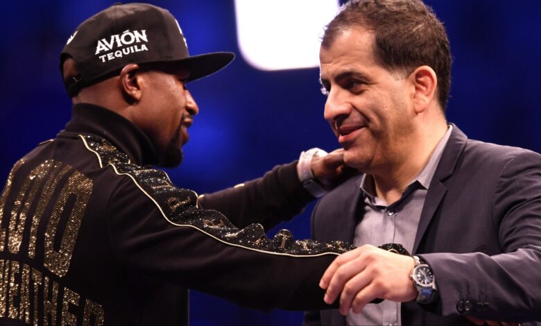 Floyd Mayweather and Showtime executive Stephen Espinoza embrace at a post-fight press conference